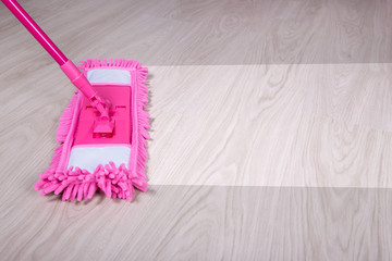 cleaning concept -close up of mop cleaning wooden floor