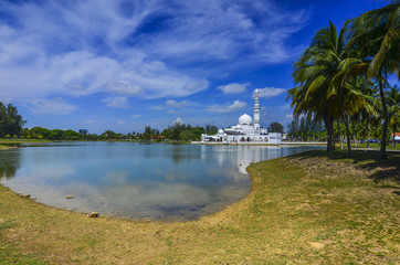 Beautiful white mosque with reflection in the lake during clean