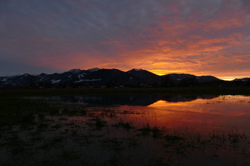 Fototapeta na wymiar Sonnenuntergang mit Spiegelung nahe den Alpen