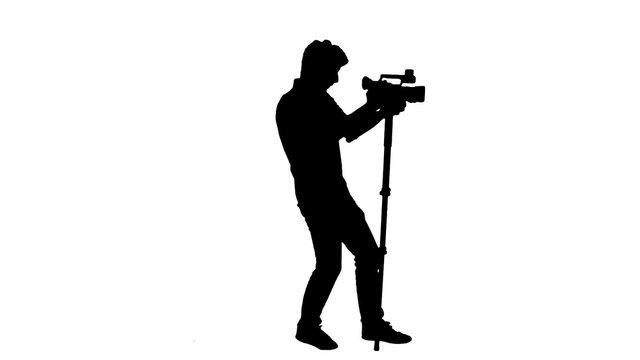 Cameraman silhouette shooting with monopod - 1080p. Silhouette of a cameraman with a monopod shooting video - Full HD
