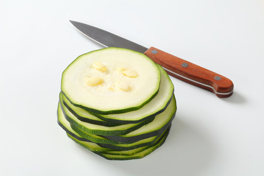 stack of sliced zucchini with a knife