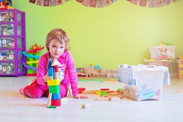 Little girl playing with wooden blocks