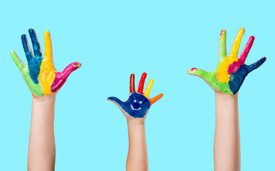 Cute smiling colorful painted hand on blue background.