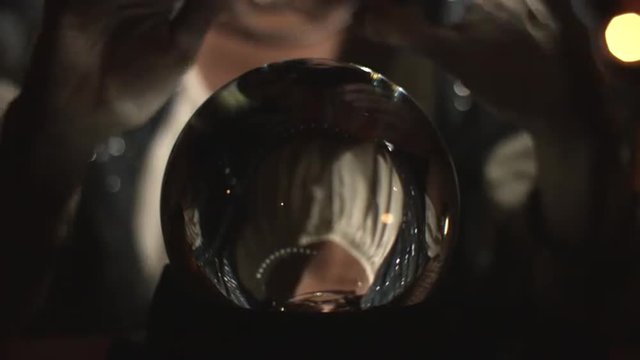 Fortune teller unveils a crystal ball.  Close up on crystal.  UHD 4K.