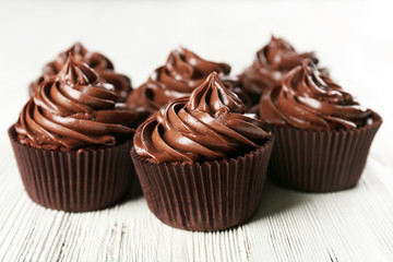 Chocolate cupcakes on light wooden background
