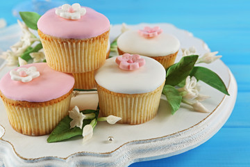 Tasty cupcakes on color wooden background