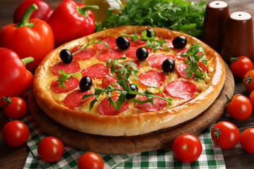 Tasty pizza with salami on decorated wooden table, close up