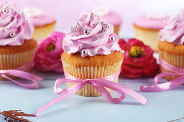 Tasty cupcakes on tray, on light background