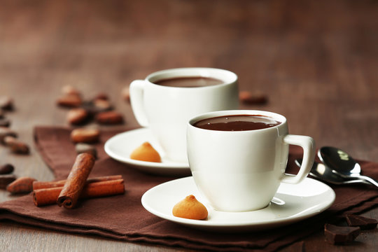 Cacao with sweets and cinnamon on cutting board