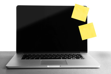 Empty yellow adhesive papers on laptop, on light background