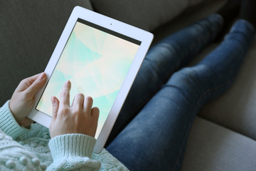 Female hand holding PC tablet on home interior background