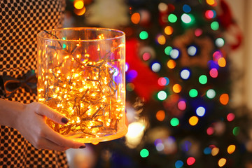 Jar with garland in woman hands