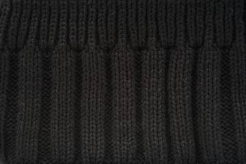 Rib knit of black melange wool yarn as background.