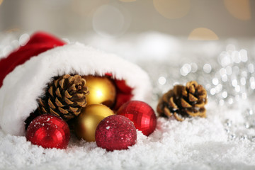Naklejka na ściany i meble Christmas decorations in red Santa hat on shiny background, close up