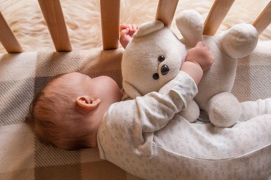Newborn sweet child sleeping with teddy bear