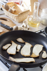 Sliced eryngii mushrooms in a fried pan, close up