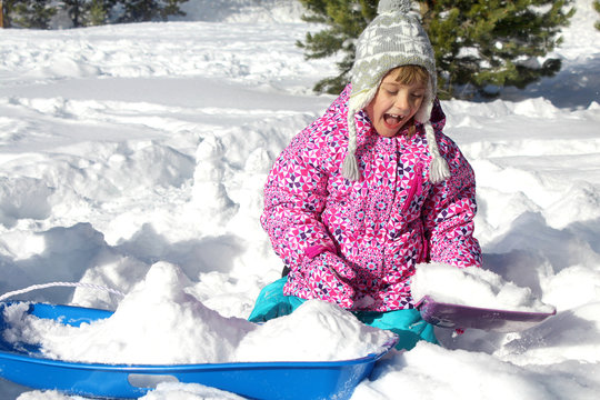 Happy winter holidays. Picture of a little girl playing with snow in a mountain forest