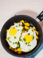 fried eggs with potato on pan