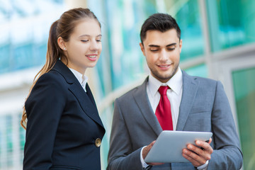 Couple of business people using a tablet outdoor