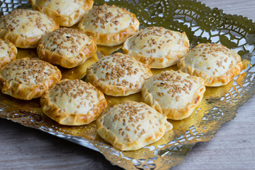 Bandeja de mini empanadas de ojaldre, bacon, queso y sésamo