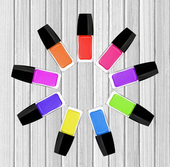 set of colorful nail polishes on white wooden background