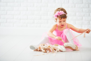 Obraz premium little child girl dreams of becoming ballerina with ballet shoe