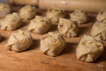 Raw Manti with meat inside (dumpling). Rows of uncooked dumplings