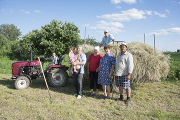 Naklejka na ściany i meble In the summer on the people harvested hay from the field and pla