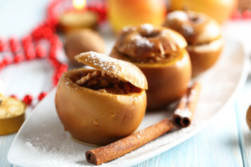 Baked apples on plate on blue wooden table