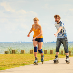 Young couple on roller skates riding outdoors