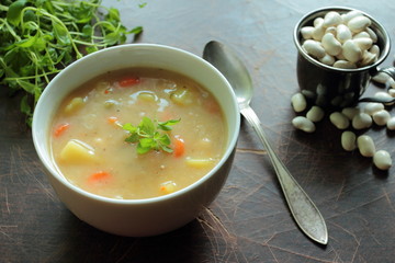 Bowl with bean soup and metal spoon