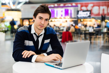 Portrait of smiling man working on laptop outdoors