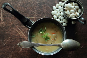 Angle view on bean soup in a small pot with a spoon
