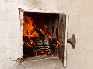 open white door, rustic stoves, burning wood and fire