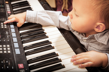 Boy child kid playing on digital keyboard piano synthesizer