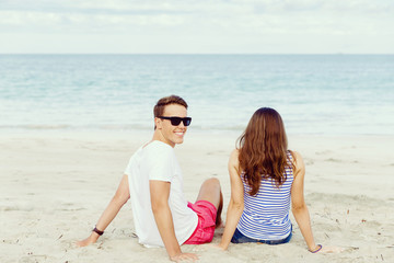 Romantic young couple sitting on the beach