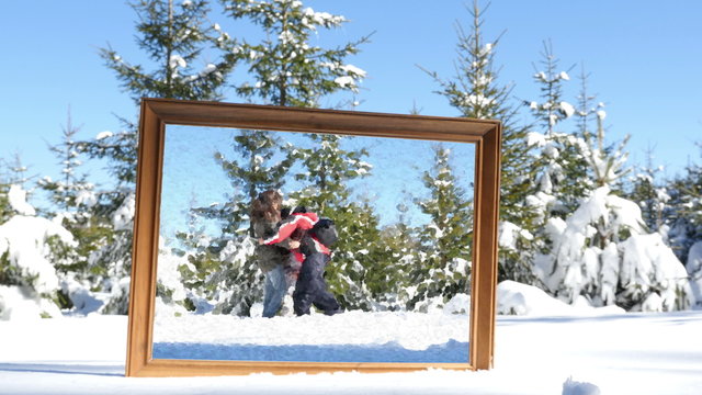 Family playing in winter snow, frame in the foreground