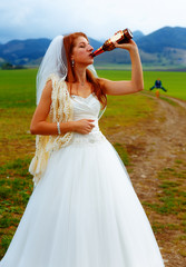 Fototapeta na wymiar bride with a beer bottle and a groom on bicycle on the background - wedding concept.
