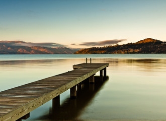 dock on mountain lake at sunrise