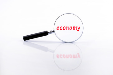 economy word on Magnifying glass in a metal frame with rubber bl