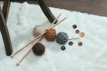 button and woolen yarn ball on carpet