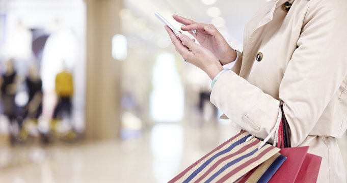 woman using cellphone while shopping