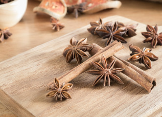 Obraz na płótnie Canvas Star anise and cinnamon sticks on wooden chopping block
