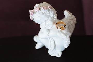Angel sculpture with wedding rings. Beautifil decor