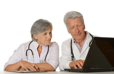 Thoughtful senior doctors sitting  with laptop