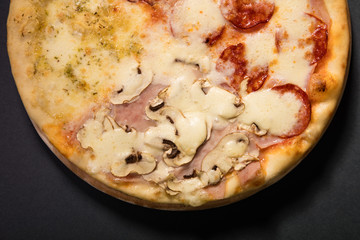 Quattro Stagioni pizza with mozzarela, ham, bacon, mushrooms...