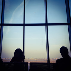 silhouette of people seatting in front of window airport