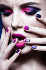 Beautiful girl with bright creative fashion makeup and colorful nail polish. Art beauty design