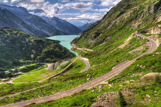 Scenic view down the Grimselpass in Switserland, with the road leading down to the lake reservoir