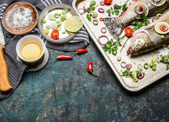 Raw fish preparation on kitchen table with cooking ingredients. Healthy food or diet concept